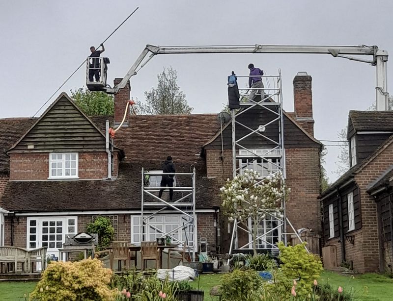The Roof Moss Cleaners using cherry picker and scaffolding to clean roof safely and professionally in Denmead, Hampshire